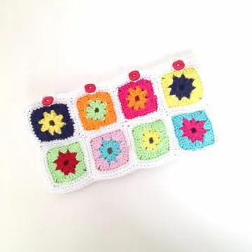 Flat view of a colorful two-row flower square crochet pencil case with four buttons
