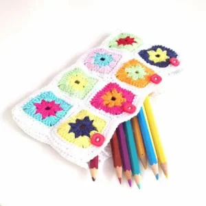Colorful flower granny-square crochet pencil case with pencils and four pink buttons