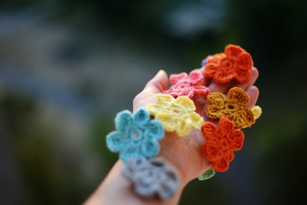 Hand holding a colorful bouquet of crocheted flowers