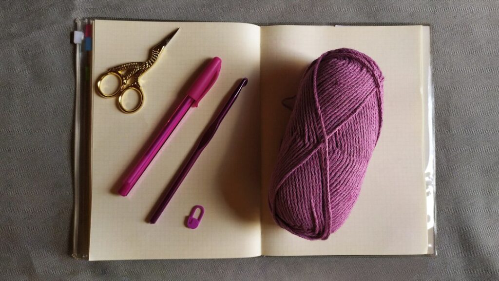 Yarn and notebook on a desk for a crochet school supplies project