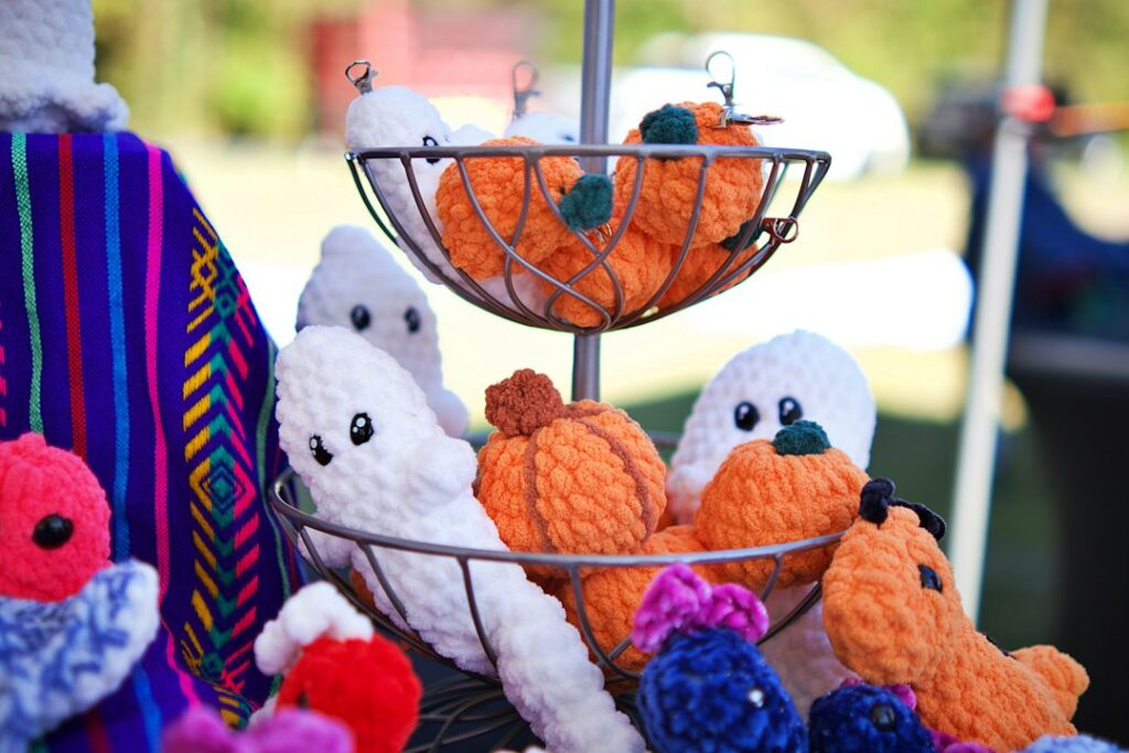 Display of handmade crochet Halloween pumpkins and ghost plush toys
