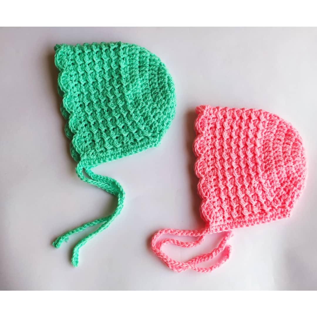 Green and pink crochet baby bonnets with scalloped edges by Toyslab Creations