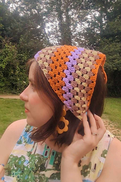 Crochet bandana with orange, lilac and pale granny stripes worn as a headscarf