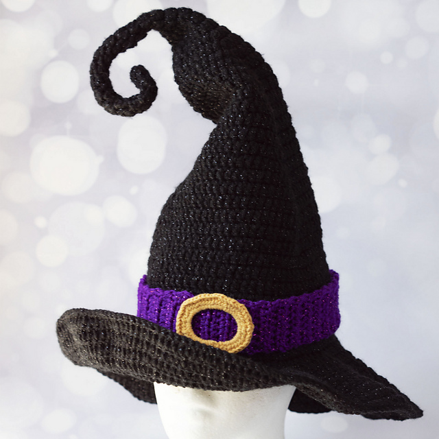 Black crochet witch hat with a curled tip, purple band and yellow buckle detail