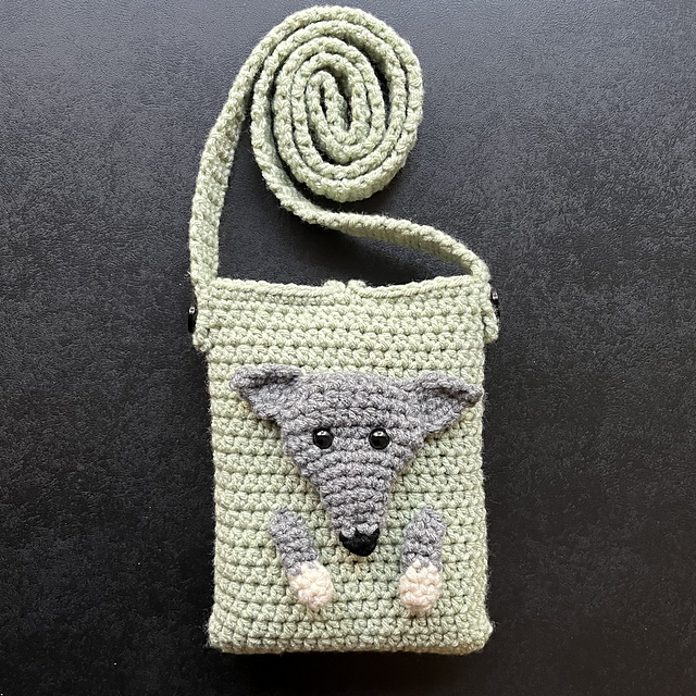 Crocheted crossbody phone bag with a dog-face flap and long strap