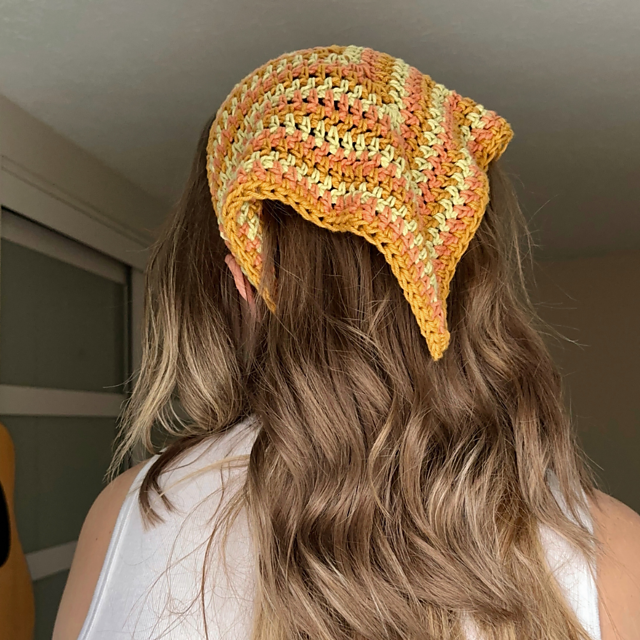 Striped crochet bandana in warm yellow, orange and cream worn over long hair