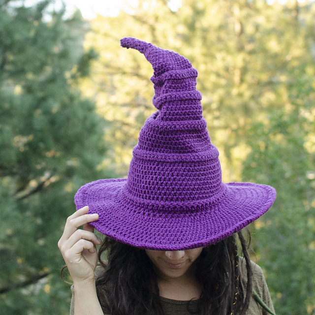 Purple crocheted witch hat with a tall bent point and broad brim