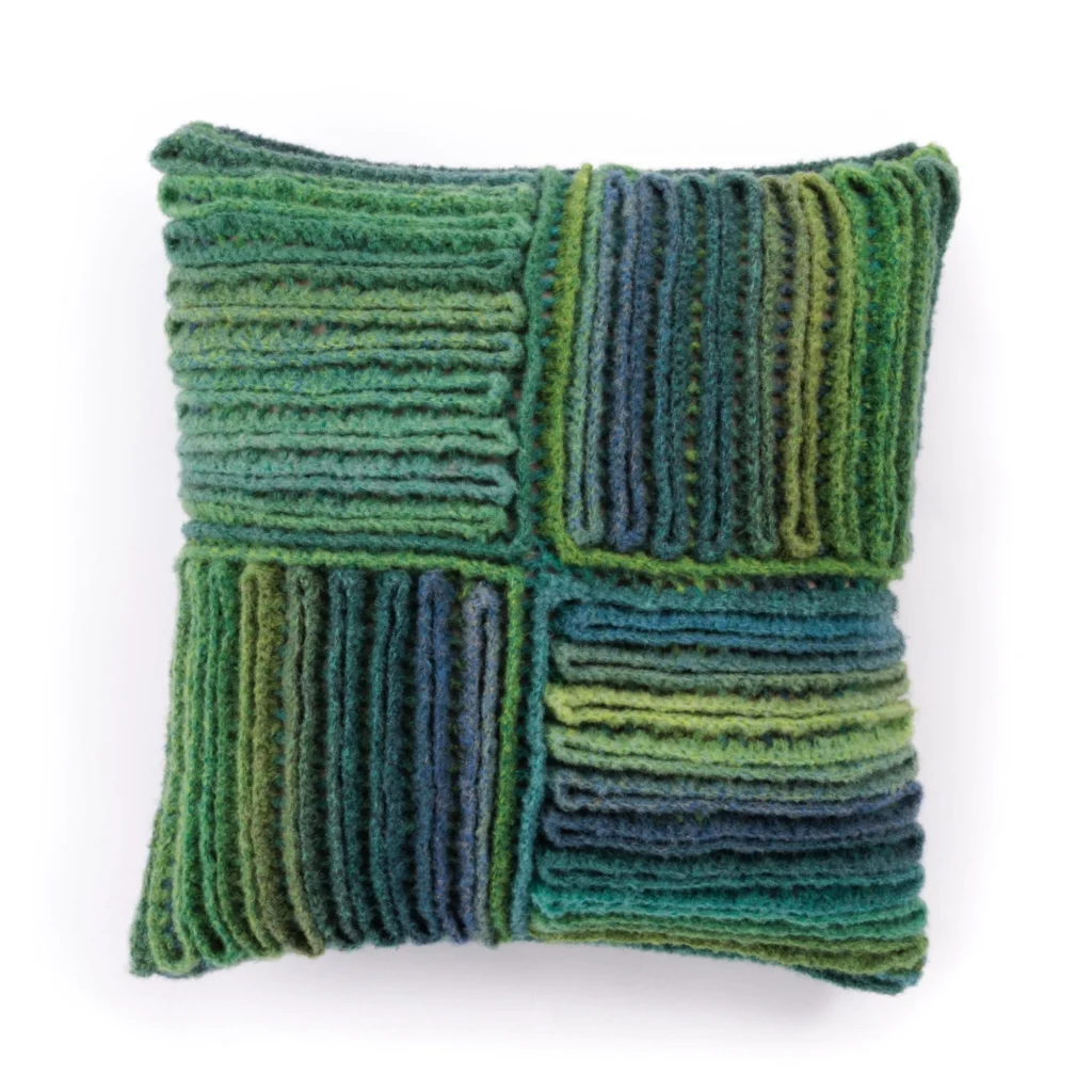 Colorful crochet pillow with a wiggly pattern enhancing home decor