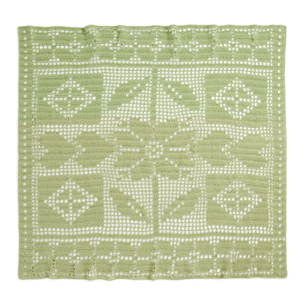 Cottagecore filet crochet throw in soft pastel colors, showcasing delicate patterns.
