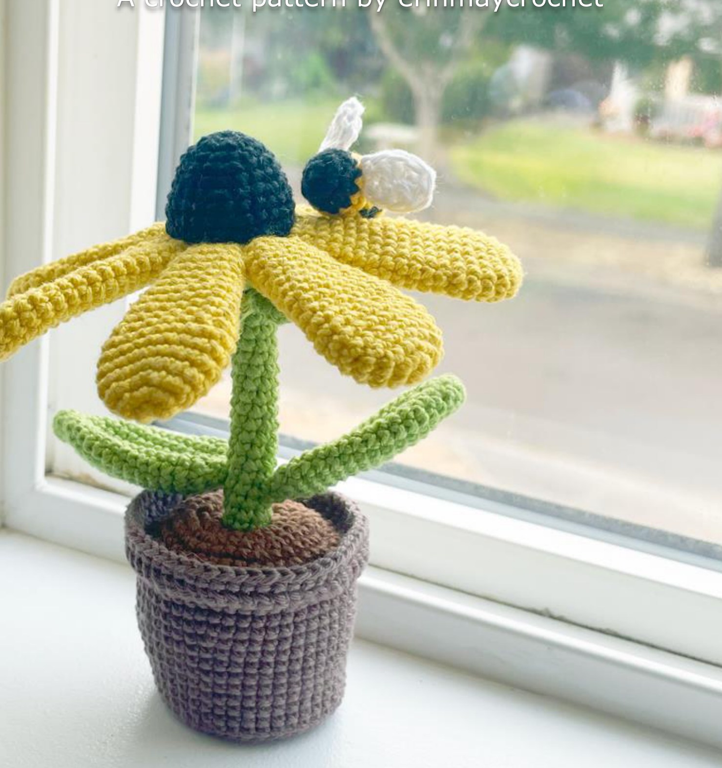 Potted crochet black-eyed Susan with yellow petals and a small bumblebee