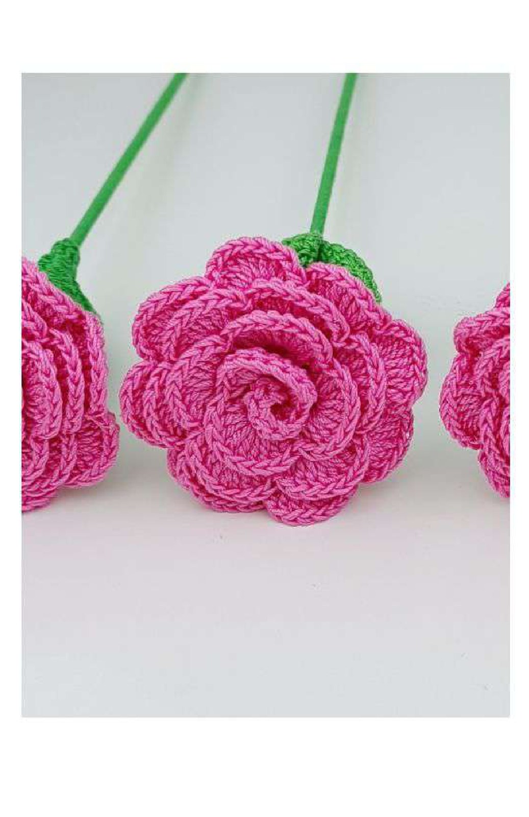 Pink crochet rose made by rolling a long scalloped strip