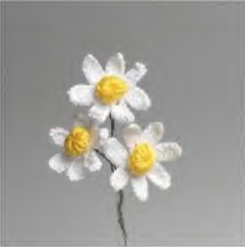 White crochet chamomile flowers with raised yellow centers