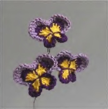Purple and yellow crochet pansy flowers from the source pattern