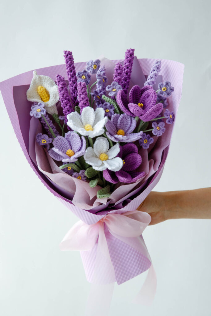 A bouquet of purple crochet lavender flowers wrapped for gifting, by Hookok.