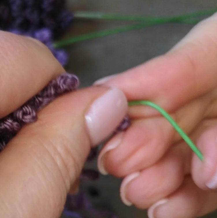 Floral wire being secured inside a purple crochet lavender head