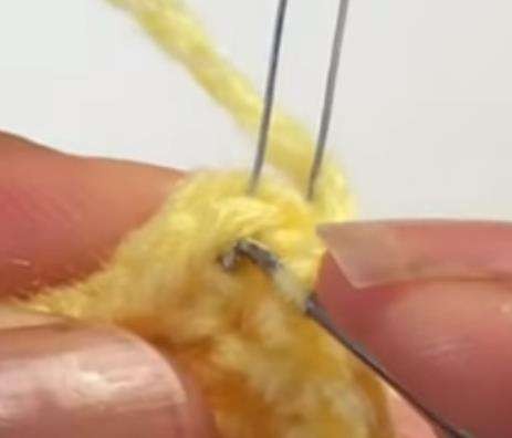 A wired yellow crochet lily petal in progress