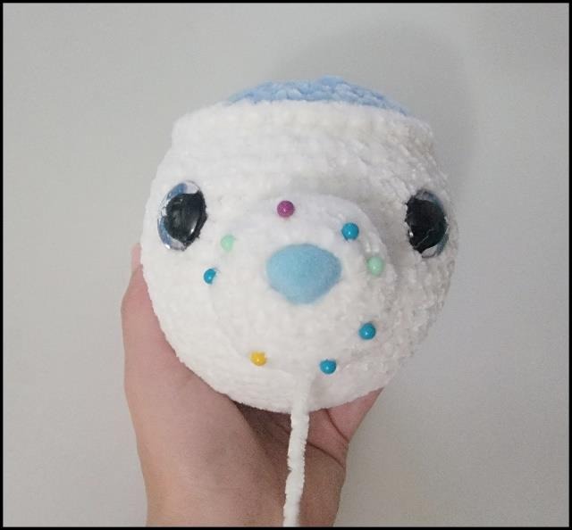 White crochet polar bear pot with its rounded muzzle and pinned ears