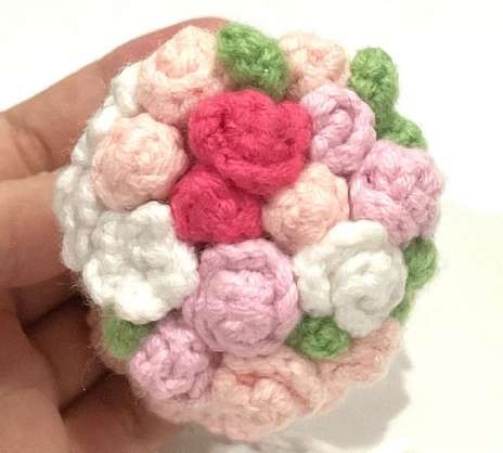 Pastel crochet flowers and small leaves arranged over the bride hair