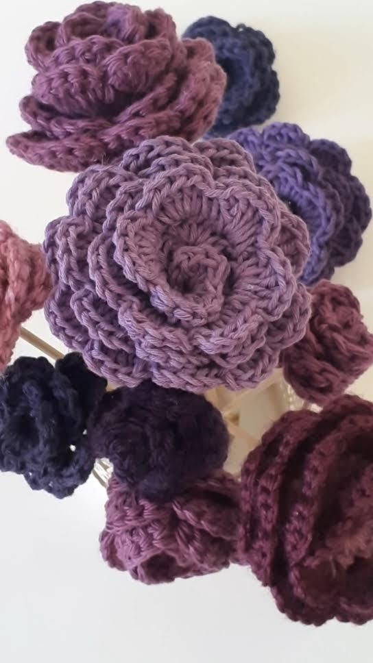 Close view of purple crochet flowers with layered rolled petals
