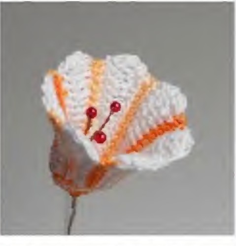 White crochet bellflower with orange stripes and three red bead stamens