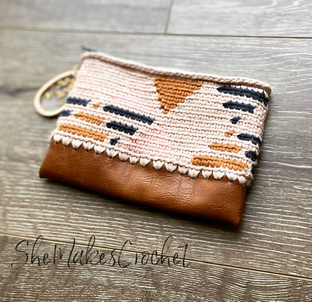 Geometric tapestry crochet zipper pouch with brown faux-leather base by Sheila Houle