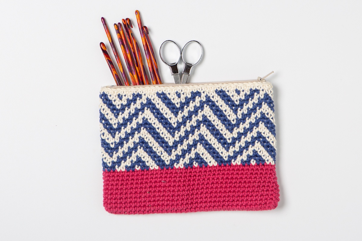 Blue and cream geometric tapestry zipper pouch with a pink base by Sara Dudek