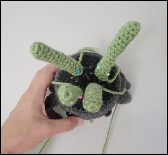 Four crochet Venus flytrap stems being positioned on the pot