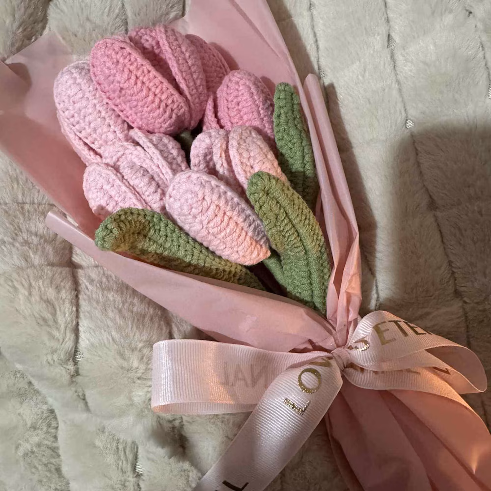 Pink crochet tulip bouquet with green leaves, blush wrapping and a satin bow