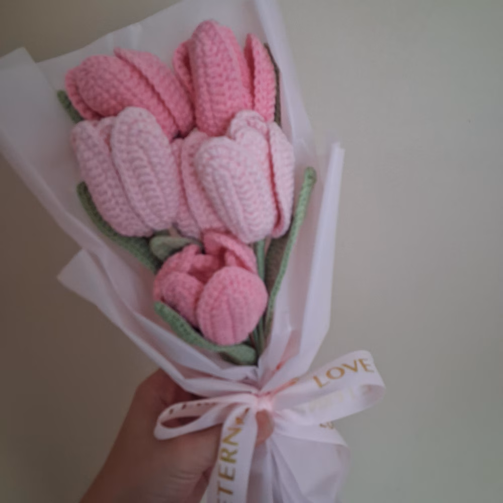 Pink crochet tulip bouquet wrapped in pale pink paper with a satin ribbon